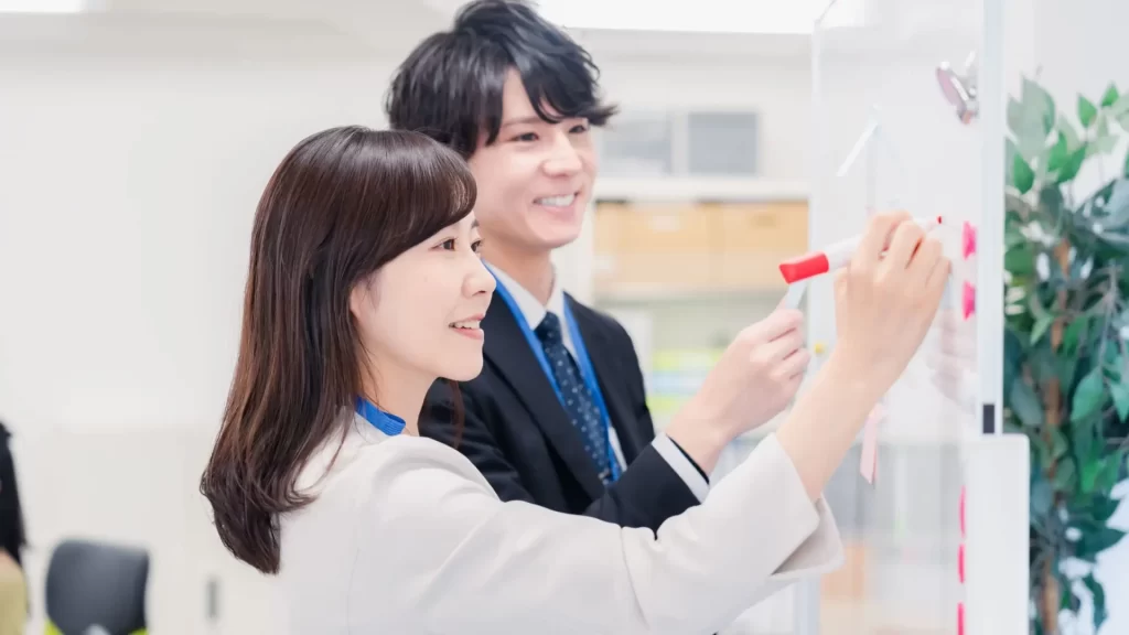 ホワイトボードを使って打ち合わせをするビジネスチーム